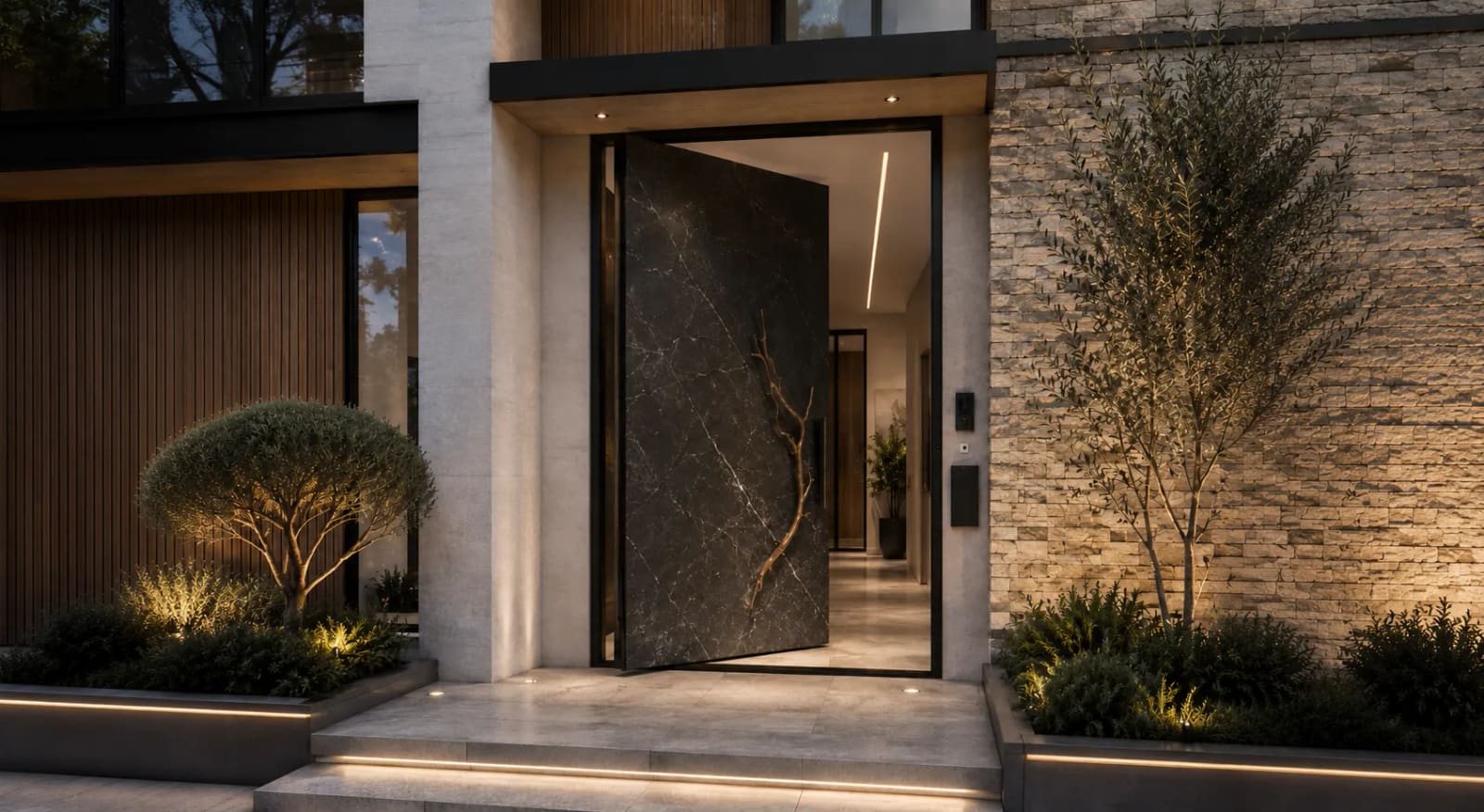 Dark marble-effect pivot front door standing open in a stacked-stone entrance at dusk