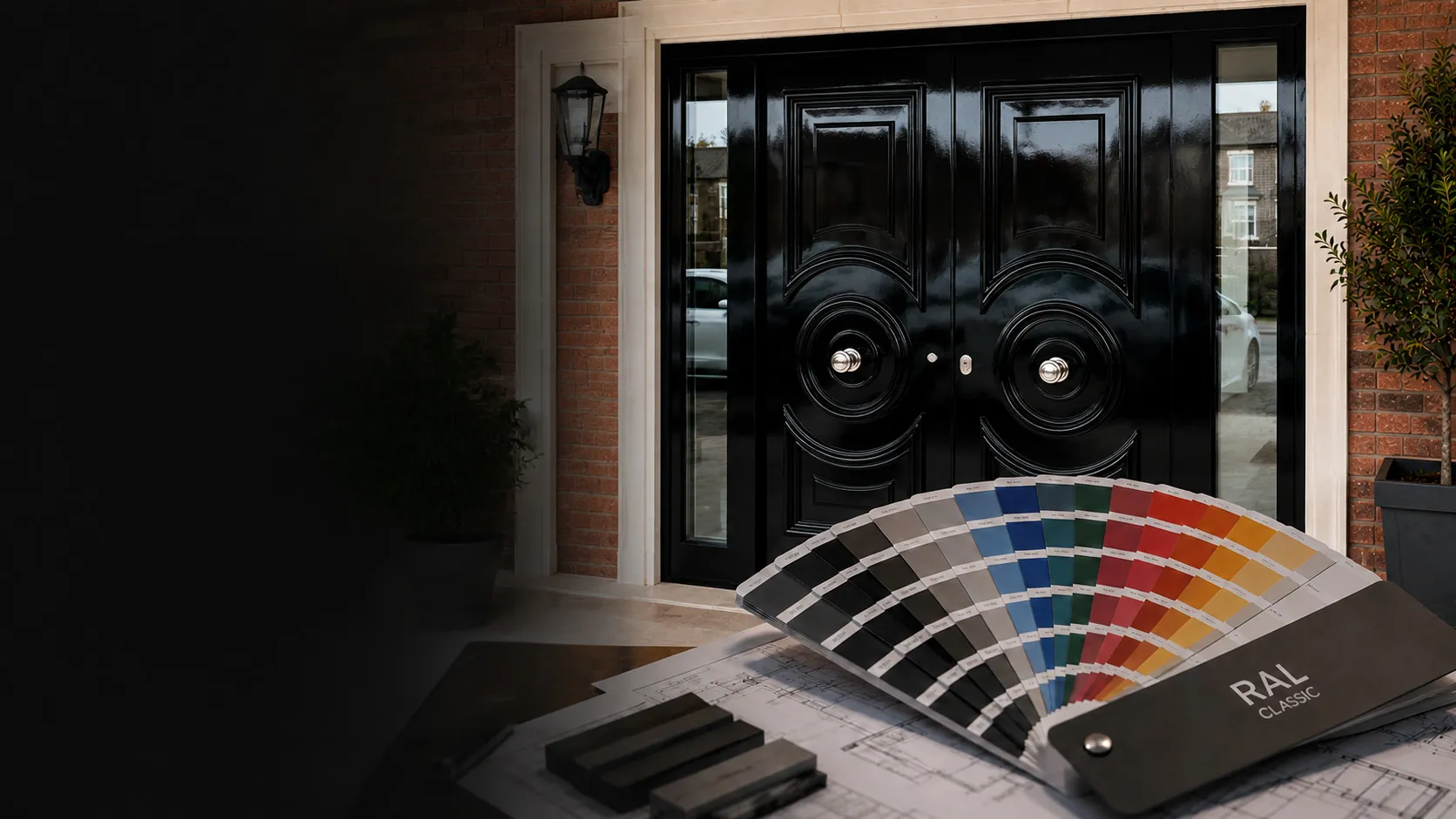 A RAL colour fan and door plans laid out beside a black gloss front door