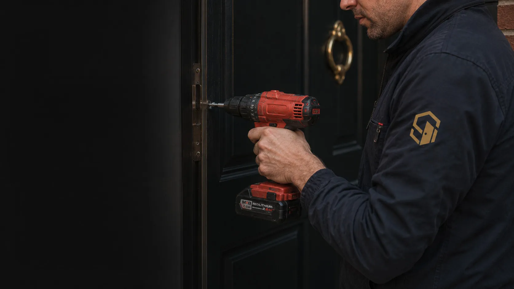 A Security Doors 'R' Us installer fitting a black front door with a cordless drill