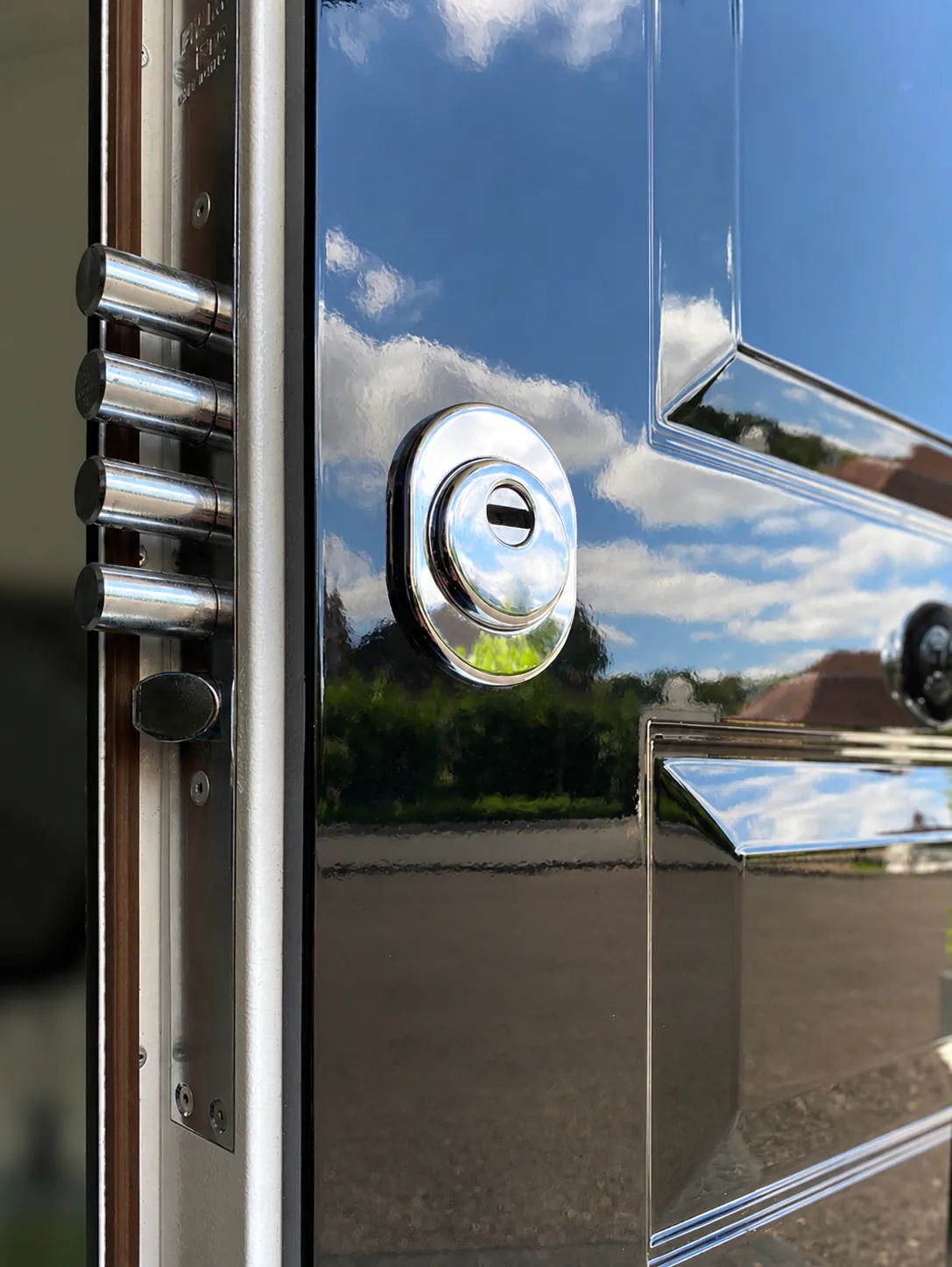 Chrome deadbolts and escutcheon on the edge of a security door