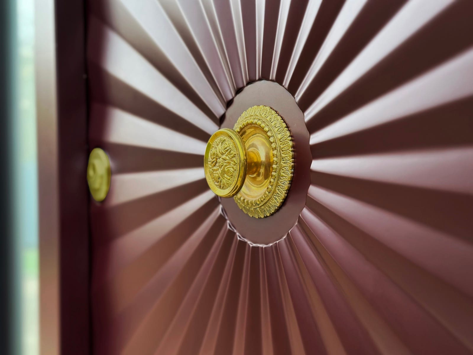 An ornate brass rosette knob centred on a fan-fluted door panel